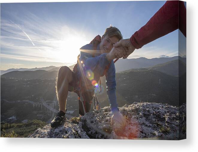 Expertise Canvas Print featuring the photograph POV down arm to young man climbing up a rock face by AscentXmedia