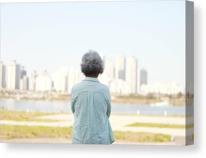 People Canvas Print featuring the photograph Rear view of senior woman standing by river bank by Runstudio