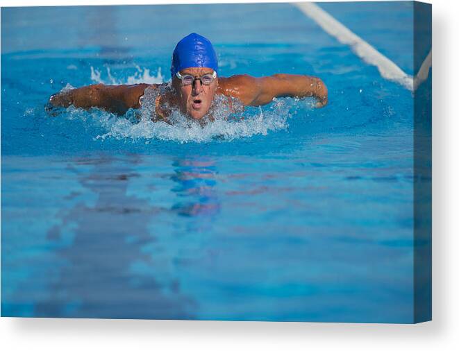 Endurance Canvas Print featuring the photograph Senior man at butterfly stroke by Technotr