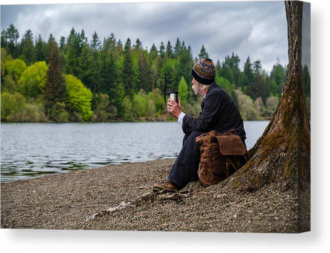 Tranquility Canvas Print featuring the photograph Senior man sitting beside a loch by JohnFScott
