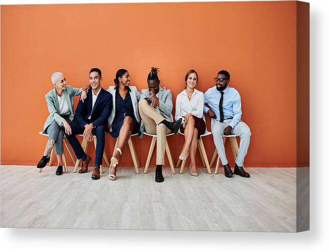 20-29 Years Canvas Print featuring the photograph Shot of a group of businesspeople sitting against an orange background by Jeffbergen