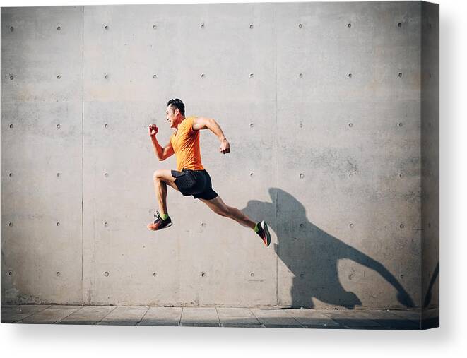 Asian And Indian Ethnicities Canvas Print featuring the photograph Sporty Asian Mid man running and jumping against shutter. Health and fitness concept. by Asia-Pacific Images Studio