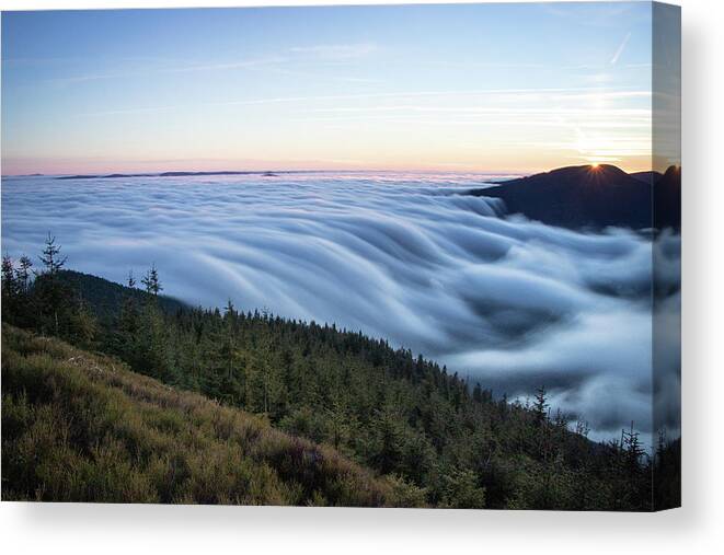 Courage Canvas Print featuring the photograph Sunset with floating blue waves of clouds by Vaclav Sonnek