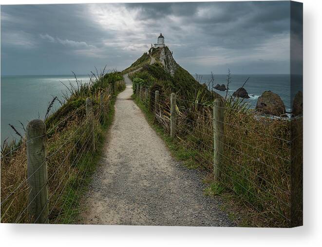 Beach Canvas Print featuring the photograph The Nugget point lighthouse on a moody and cloudy afternoon by Anges Van der Logt