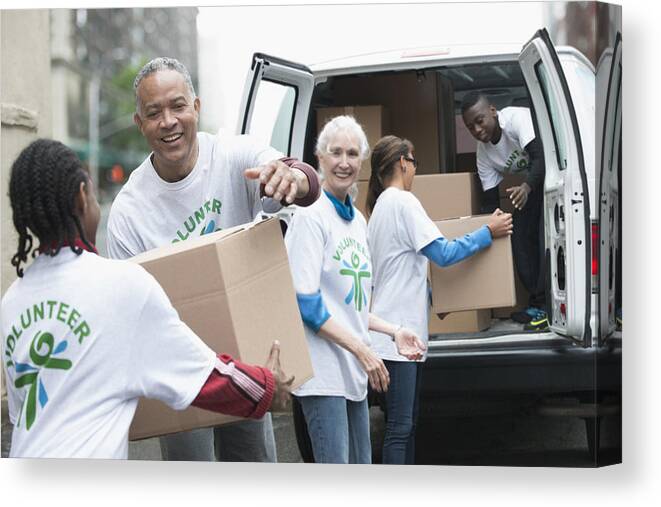 Three Quarter Length Canvas Print featuring the photograph Volunteers passing cardboard boxes from delivery van by Jose Luis Pelaez Inc