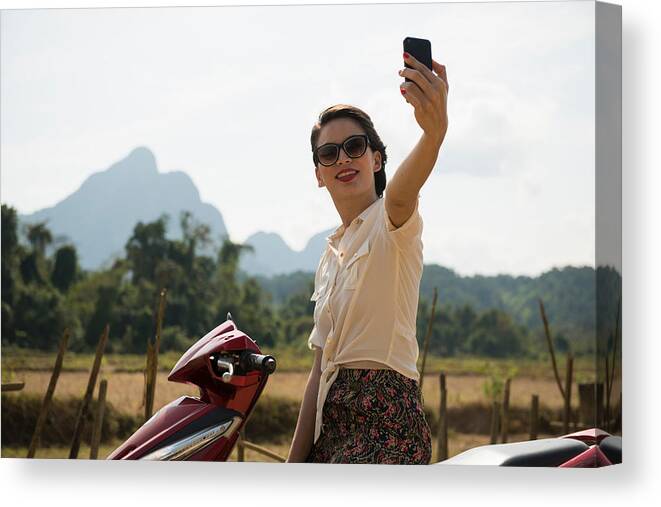 Scenics Canvas Print featuring the photograph Woman photographing self on moped, Vang Vieng, Laos by Ben Pipe Photography
