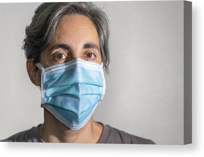Cold And Flu Canvas Print featuring the photograph Woman wearing a surgical mask, protective face mask against infectious diseases like coronavirus and influenza by Andrew Merry