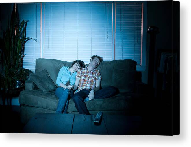 Young Men Canvas Print featuring the photograph Young couple fallen asleep in front of tv by Image Source
