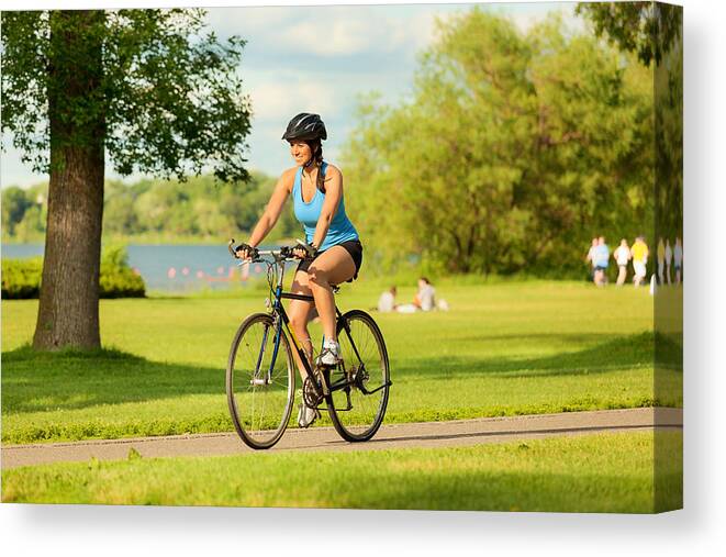 Scenics Canvas Print featuring the photograph Young Healthy Woman Exercising on Bicycle in Urban City by YinYang