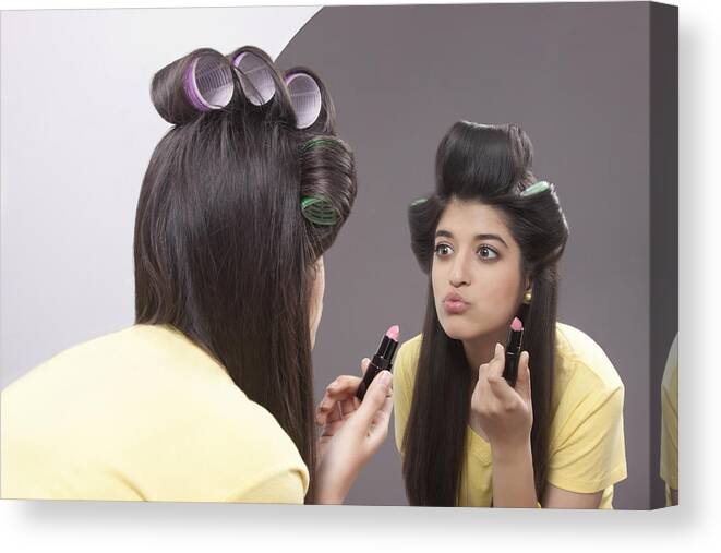 Casual Clothing Canvas Print featuring the photograph Young woman applying lipstick by IndiaPix/IndiaPicture