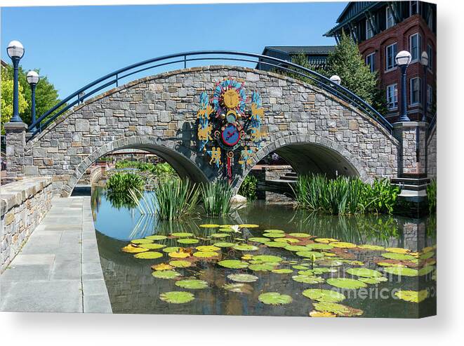 Carroll Creek Canvas Print featuring the photograph Zodiac inspired clock on a stone bridge in Carroll Creek Park in Frederick Maryland by William Kuta