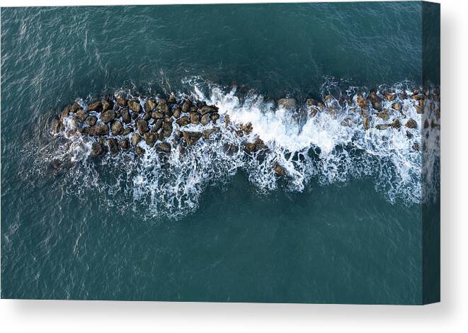 Ocean Canvas Print featuring the photograph Aerial view from a flying drone of blue sea water and break water. Sea wall coastline by Michalakis Ppalis