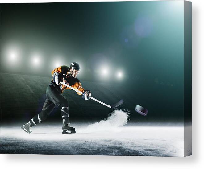 Sports Helmet Canvas Print featuring the photograph Ice hockey player passing puck. by Robert Decelis Ltd