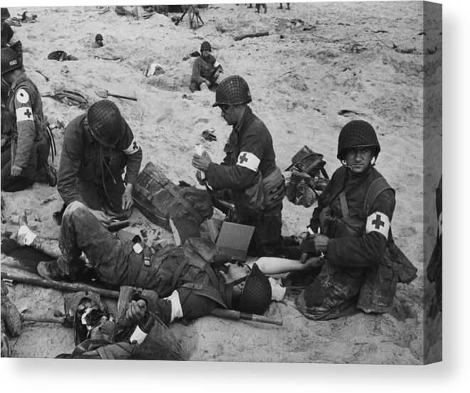 History Canvas Print featuring the photograph Medics Treat A Wounded U.s. Soldier by Everett