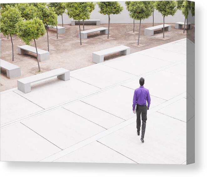 Corporate Business Canvas Print featuring the photograph Businessman walking in modern courtyard by Robert Daly