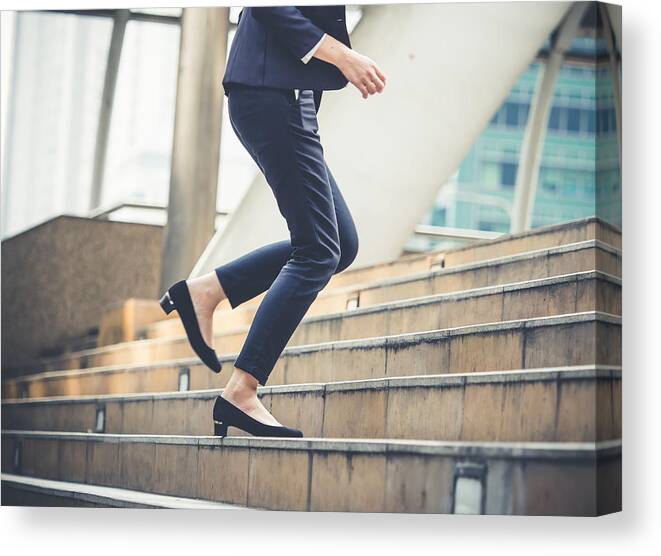 Young Men Canvas Print featuring the photograph Close up legs of businesswoman walking stepping up stair in modern city, business growth, go up, success, grow up business concept by Nattakorn Maneerat