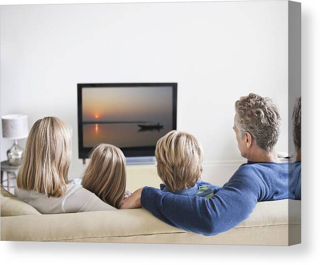 Mature Adult Canvas Print featuring the photograph Family watching television, rear view by Compassionate Eye Foundation/Rob Daly/OJO Images Ltd