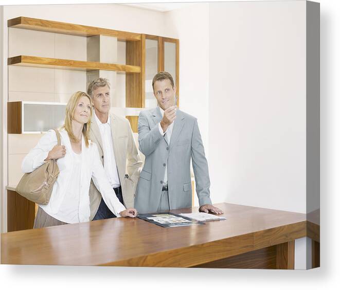 Showing Canvas Print featuring the photograph Salesman with couple in interior design showroom by Robert Daly