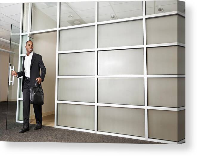 Young Men Canvas Print featuring the photograph Mixed race businessman leaving modern office by Tanya Constantine