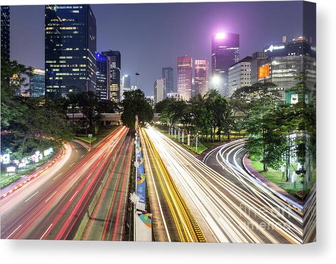 Capital Cities Canvas Print featuring the photograph Traffic night rush in Jakarta, Indonesia capital city. by Didier Marti