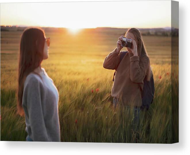 Teenagers Canvas Print featuring the photograph Two Women Holding Hands At Sunset In The Field #1 by Cavan Images