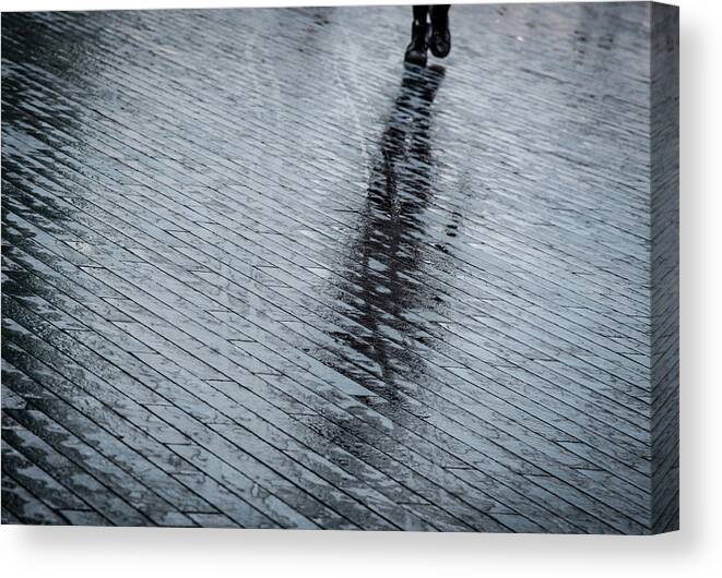 Silhouette Canvas Print featuring the photograph Walking shadow of an unrecognised person walking on wet streets by Michalakis Ppalis