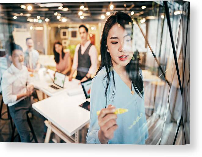 New Business Canvas Print featuring the photograph Asian Businesswoman presenting her ideas for company development by Pekic