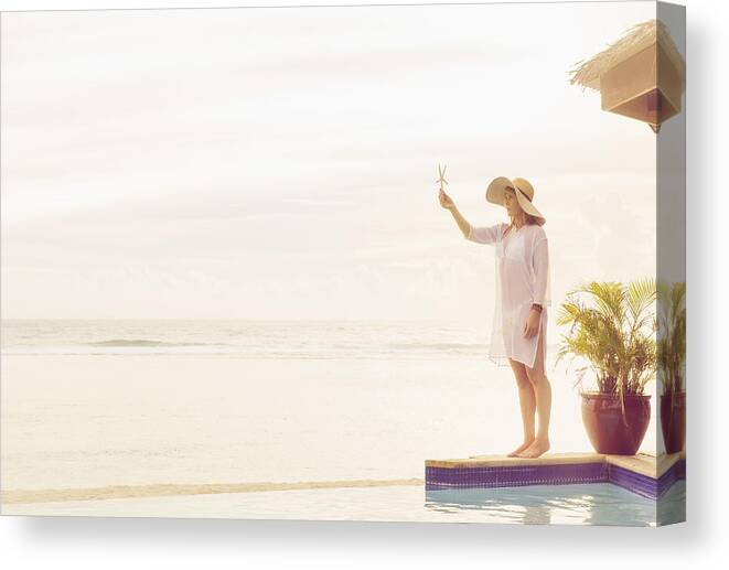 Tranquility Canvas Print featuring the photograph Caucasian woman holding starfish near swimming pool by Jacobs Stock Photography Ltd