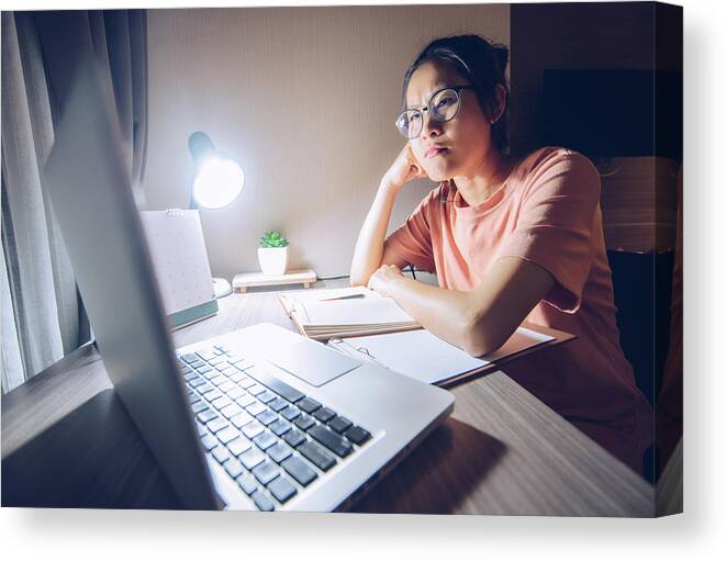 Looking Canvas Print featuring the photograph Portrait of Asian woman working late at night. by Boy_Anupong