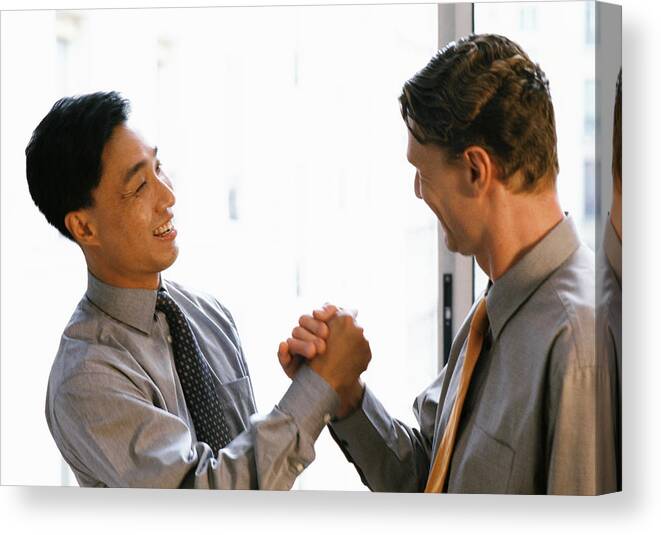 Office Canvas Print featuring the photograph Two men shaking hands, side view by James Hardy