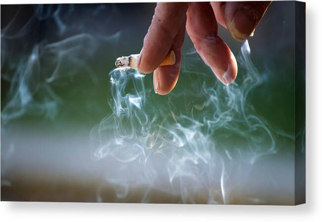 Smoking Canvas Print featuring the photograph Hand holding burning cigarette by Luis Diaz Devesa