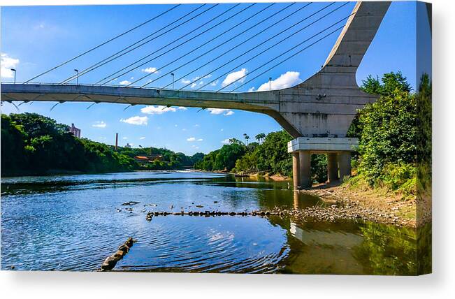 Scenics Canvas Print featuring the photograph Cable-stayed bridge over the Piracicaba River in a dry season, under blue sky between clouds. by CRMacedonio