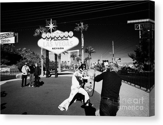 Welcome Canvas Print featuring the photograph elvis impersonator taking photos with tourists at the welcome to fabulous Las Vegas sign Nevada USA by Joe Fox