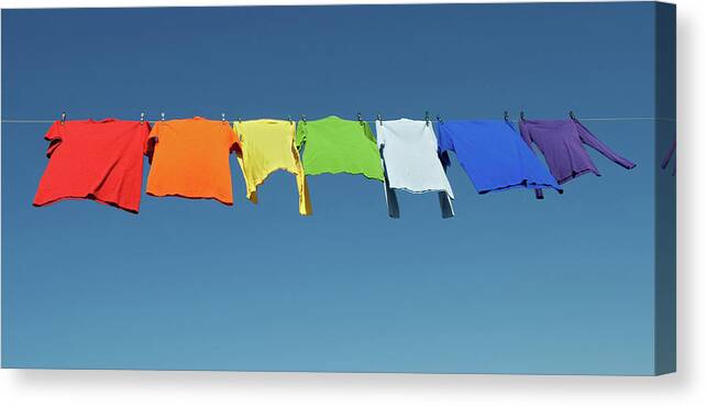 Laundry Canvas Print featuring the photograph Rainbow laundry, bright shirts on a clothesline by GoodMood Art