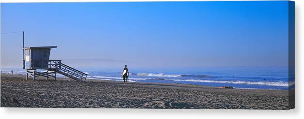 Photography Canvas Print featuring the photograph Rear View Of A Surfer On The Beach by Panoramic Images