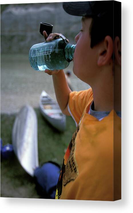 Boy Canvas Print featuring the photograph A Boy Drinks From A Water Bottle by Corey Rich