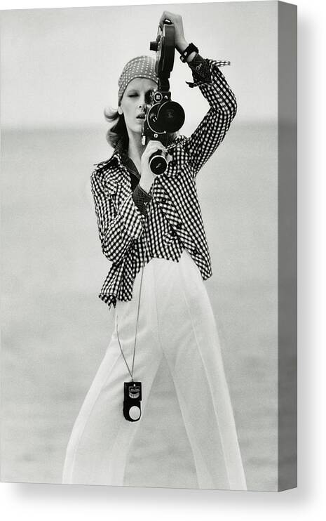 Fashion Canvas Print featuring the photograph A Model Looking Through A Beaulieu Camera Wearing by Gianni Penati