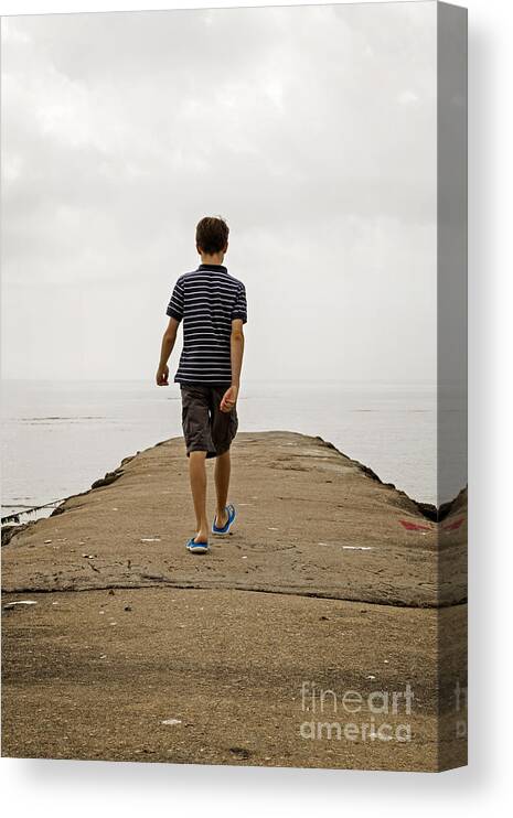 Beach Canvas Print featuring the photograph Boy walking on concrete beach pier by Edward Fielding