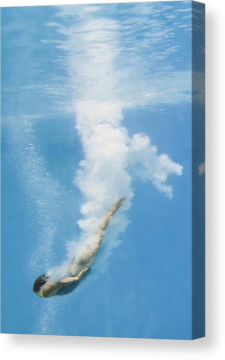 Underwater Canvas Print featuring the photograph Female diver in pool, underwater view, (blurred motion) by David Madison