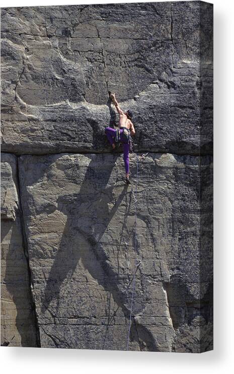 Internet Canvas Print featuring the photograph Man climbing rock wall by Comstock