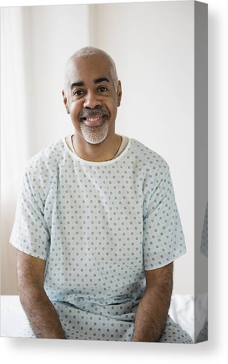 Three Quarter Length Canvas Print featuring the photograph Mixed race older man sitting on hospital bed by JGI/Jamie Grill