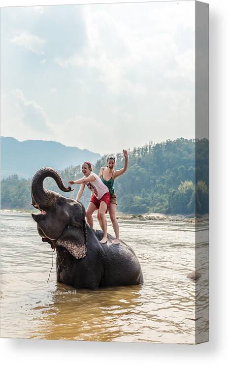 Scenics Canvas Print featuring the photograph Two young women riding an elephant in the Mekong by Matteo Colombo