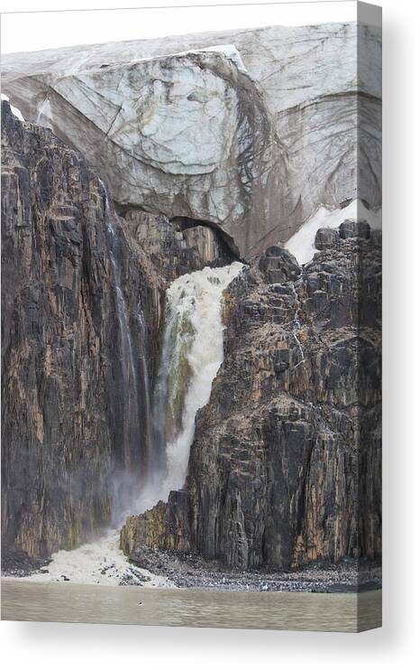 Melting Canvas Print featuring the photograph Waterfall Flowing From A Glacier Into by Anna Henly
