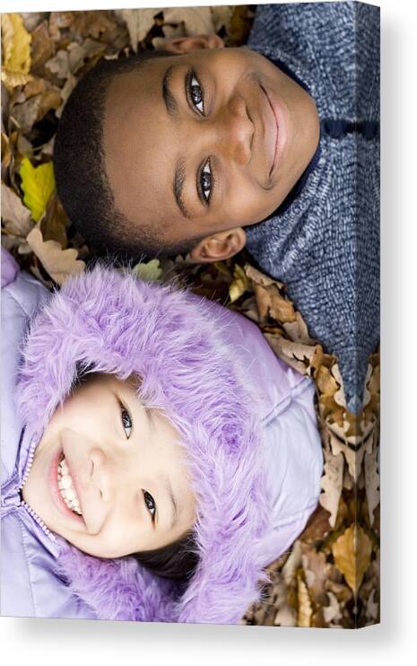 Human Canvas Print featuring the photograph Smiling Children Lying On Autumn Leaves #6 by Ian Boddy