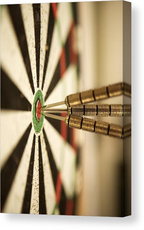 Close-up Canvas Print featuring the photograph Darts In Bull's-eye Of Target by Thinkstock