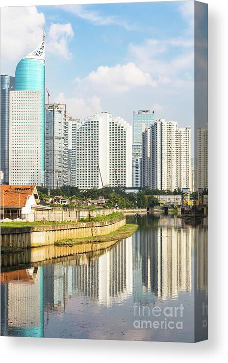 Capital Cities Canvas Print featuring the photograph Tall buildings reflection in water in Jakarta business district #1 by Didier Marti
