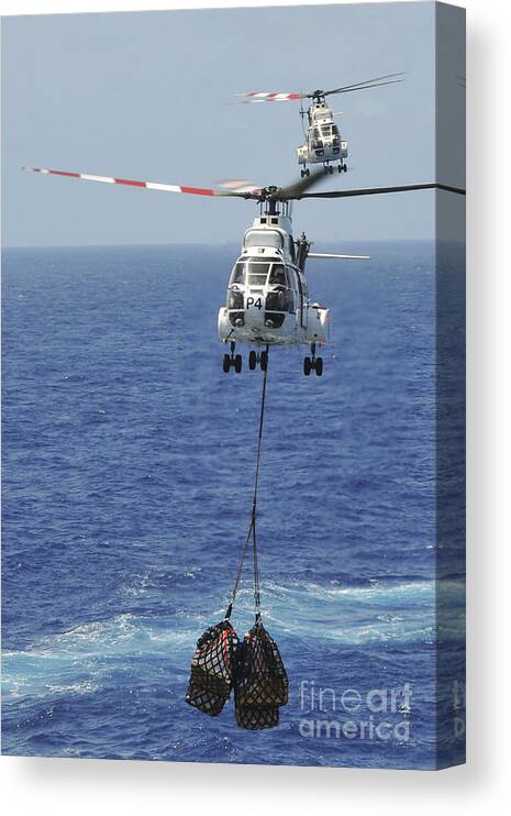 Replenishment At Sea Canvas Print featuring the photograph Two Sa-330 Puma Helicopters Deliver by Stocktrek Images