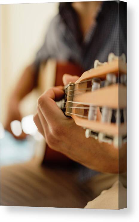 Bedroom Canvas Print featuring the photograph Close Up Of Male Hands Playing Classic Guitar Indoors #3 by Cavan Images