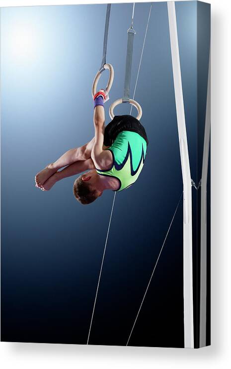 Hanging Canvas Print featuring the photograph Male Gymnast Performing Somersault On by Robert Decelis Ltd