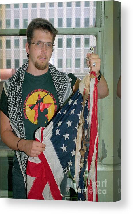 1980-1989 Canvas Print featuring the photograph Man Holding Burned American Flag by Bettmann